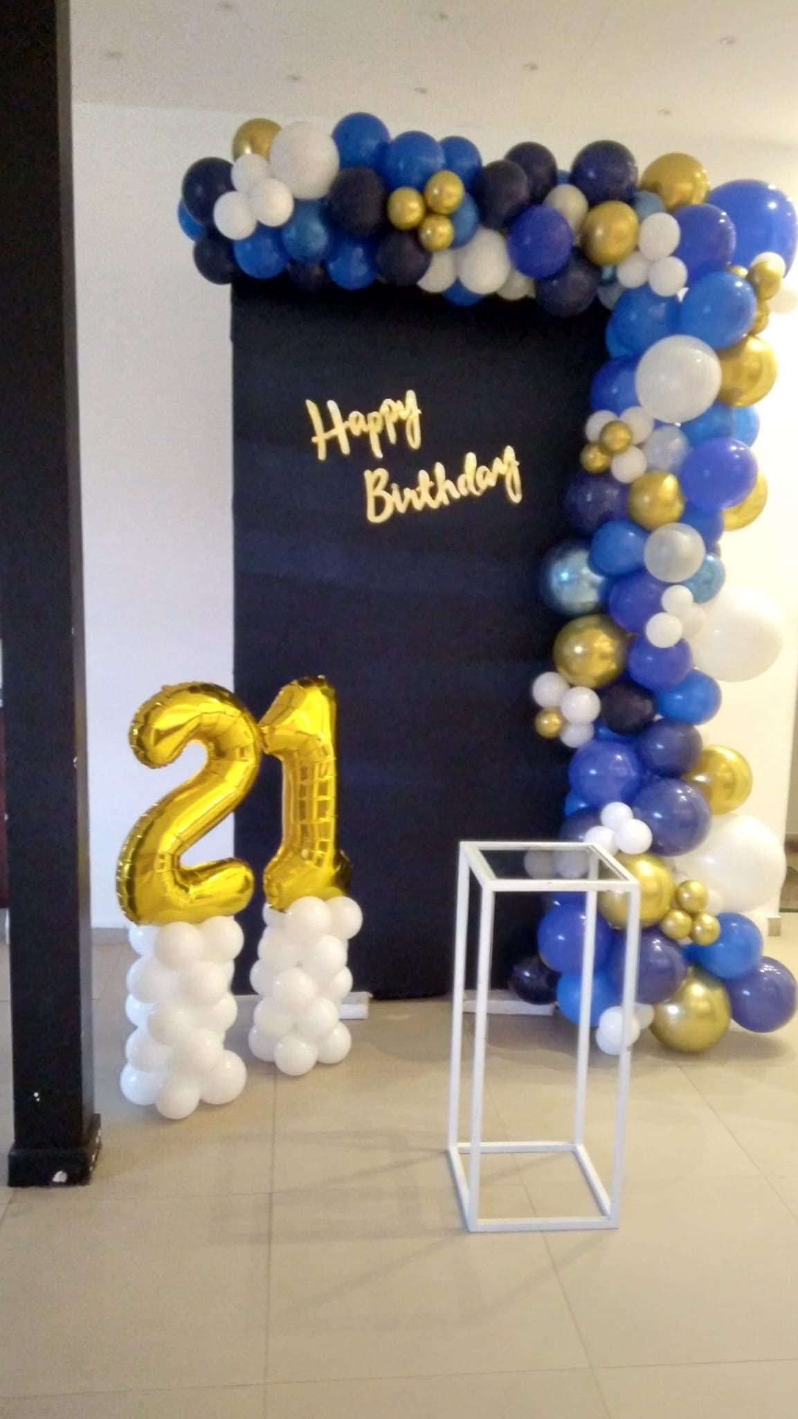 Navy, white and gold balloon backdrop with gold 21 number balloons for a 21st birthday
