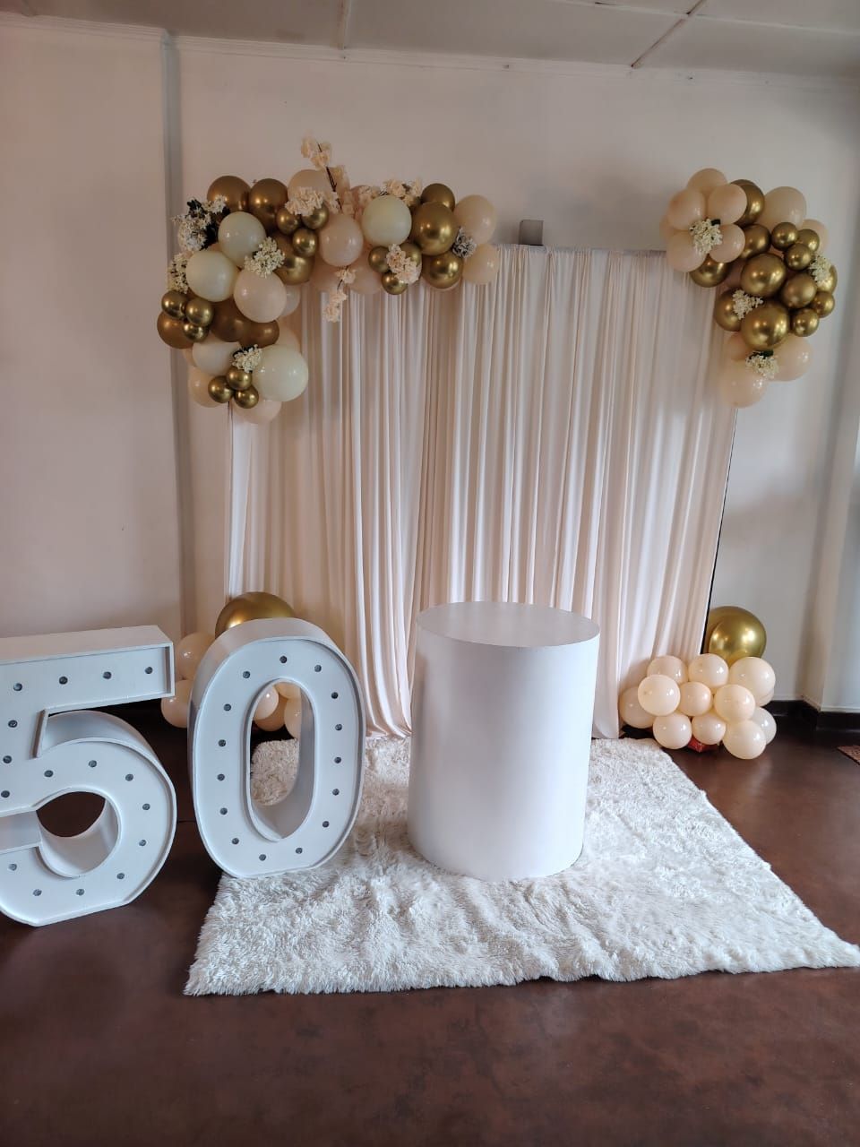 Elegant 50th birthday balloon backdrop decoration with gold and white balloons